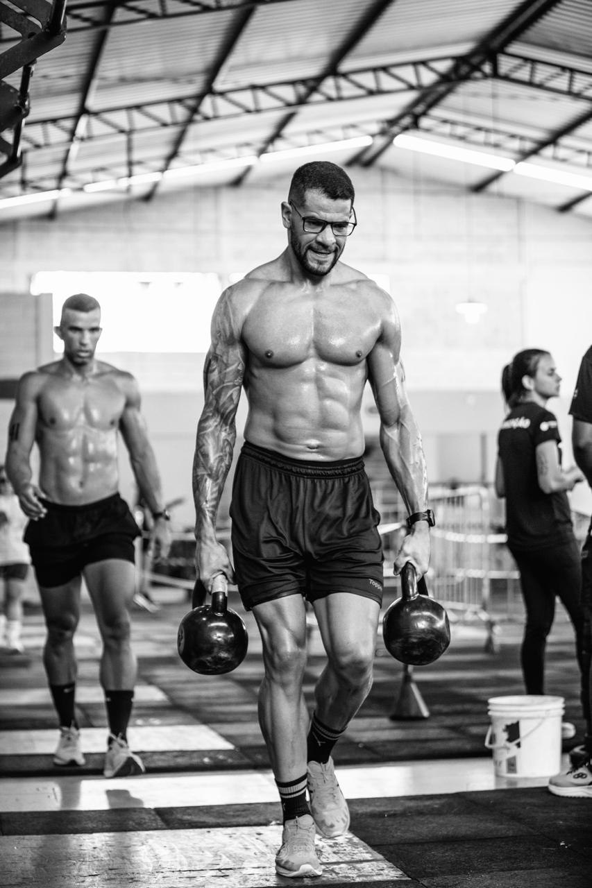 Juninho, o Personal Ribeiro, carregando kettlebells durante uma competição
